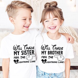 May include: Two children wearing white t-shirts with black text. The shirts read "Will Trade My Sister For The Lightning Lane" and "Will Trade My Brother For The Lightning Lane". The text is in a whimsical font with a Mickey Mouse hand pointing to the right.