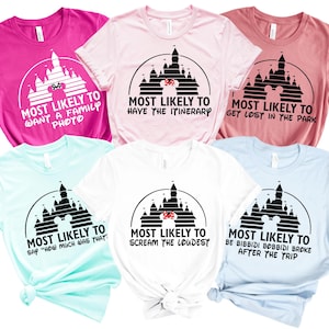 Op de afbeelding: Een verzameling van zes korte mouwen T-shirts in verschillende kleuren, waaronder roze, lichtroze, koraal, lichtblauw, wit en teal. Elk shirt heeft een zwarte afbeelding van een kasteel en tekst met "Most Likely To" en een grappige zin.