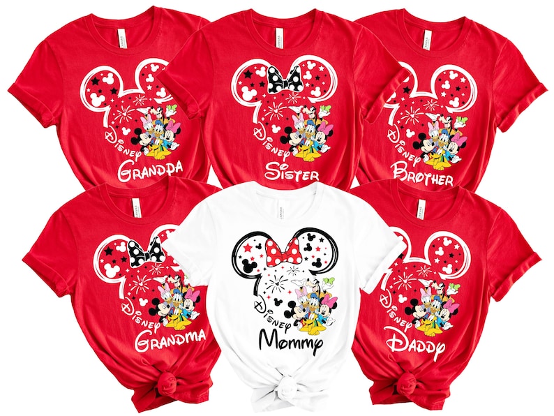 Puede incluir: Camisetas rojas y blancas con dise&ntilde;os de personajes de Disney. Las camisetas presentan orejas de Mickey Mouse, fuegos artificiales y las palabras "Grandpa", "Sister", "Brother", "Grandma", "Mommy" y "Daddy".