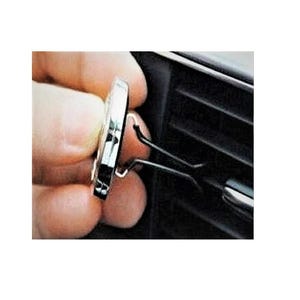May include: A silver car air freshener with a black clip. The clip is attached to a car air vent.