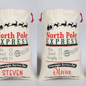Pu&ograve; includere: Due sacchi di Babbo Natale in tela bianca con laccetti di chiusura rossi. I sacchi hanno un'illustrazione in bianco e nero della slitta di Babbo Natale con le renne che volano nell'aria. Il testo "North Pole Express" &egrave; stampato in rosso e verde. Sotto l'illustrazione c'&egrave; un elenco di "Nice", "Special" e "Naughty" con caselle di controllo accanto a ciascuna. Il testo "Overnight Service For" &egrave; stampato in rosso. Il nome "STEVEN" &egrave; stampato in rosso su un sacco e il nome "Olivia" &egrave; stampato in rosso sull'altro sacco.