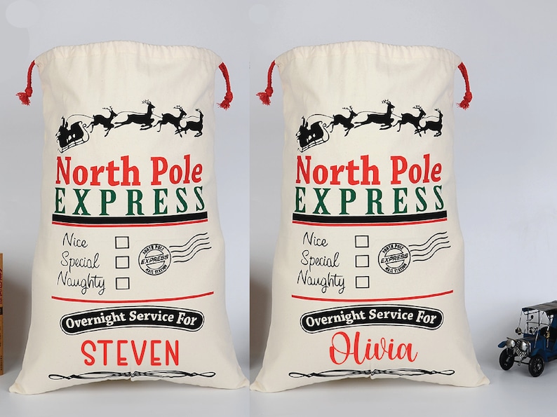 Pu&ograve; includere: Due sacchi di Babbo Natale in tela bianca con laccetti di chiusura rossi. I sacchi hanno un'illustrazione in bianco e nero della slitta di Babbo Natale con le renne che volano nell'aria. Il testo "North Pole Express" &egrave; stampato in rosso e verde. Sotto l'illustrazione c'&egrave; un elenco di "Nice", "Special" e "Naughty" con caselle di controllo accanto a ciascuna. Il testo "Overnight Service For" &egrave; stampato in rosso. Il nome "STEVEN" &egrave; stampato in rosso su un sacco e il nome "Olivia" &egrave; stampato in rosso sull'altro sacco.