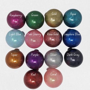 K&ouml;nnte beinhalten: Sortiment von 16 Glitzerkugeln in verschiedenen Farben, darunter Himbeere, Gr&uuml;n, Gold, Aqua, Hellblau, Rosa Kirsche, Ros&eacute;gold, Saphirblau, Topas, Lila, Silber, Dunkelgrau, Rot und Koralle.