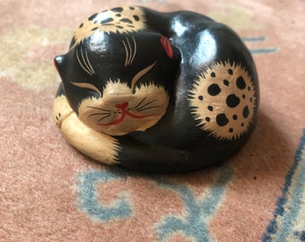 Escultura vintage de gato dormindo em madeira, pintada à mão, nas cores preto, creme e vermelho.