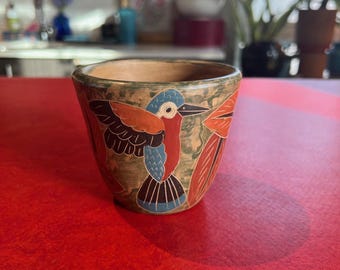 Linda caneca de cerâmica artesanal com motivos florais e de pássaros.