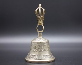 May include: A silver bell with intricate designs and a gold crown-shaped handle with a face on it.