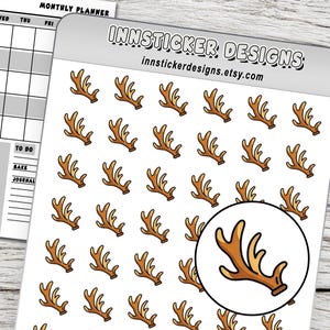 May include: A sticker sheet featuring multiple small brown reindeer antler illustrations arranged in a grid pattern. The top header displays the text INNSTICKER DESIGNS and innstickerdesigns.etsy.com. A large circular inset highlights one antler.