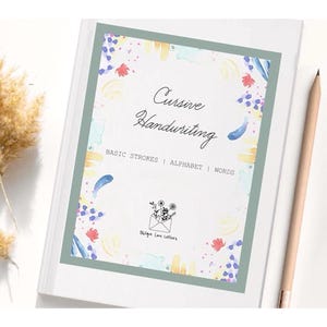 May include: A white workbook titled Cursive Handwriting with the subtitle BASIC STROKES | ALPHABET | WORDS. The cover features a sage green border and colorful watercolor accents. A small black line drawing of an envelope with flowers is centered.