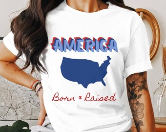 May include: White t-shirt with a blue and red graphic of the United States of America and the text "America Born & Raised".