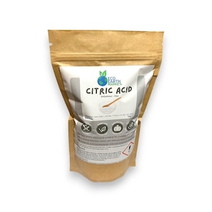 May include: A brown paper bag with a white label displaying "CITRIC ACID" in bold text. The label also shows the brand "Eco Earth Market" and a leaf graphic. The bag contains 1 kg of citric acid.