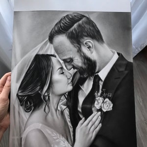 May include: Black and white drawing of a couple in a wedding setting. The bride is wearing a white dress and veil, and the groom is wearing a suit and tie. The couple is looking at each other with love and affection. The drawing is signed "Dyachenko Art Studio".
