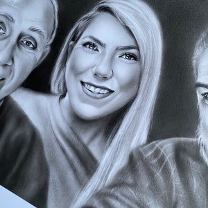 May include: A black and white portrait drawing of three people. The woman in the center is smiling and has long hair. The man on the left is looking at the camera. The man on the right is looking to the left.