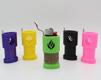 May include: A collection of colorful lighter sleeves in purple, yellow, green, black, and pink. Each sleeve has a flame design and a metal rod. The green lighter is lit, with a brown twine wrapped around it.