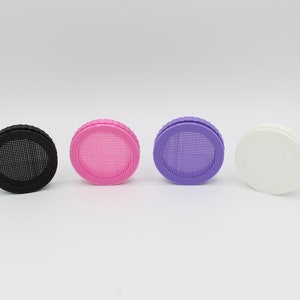 May include: Four round bottle caps with a mesh screen. The caps are black, pink, purple, and white.