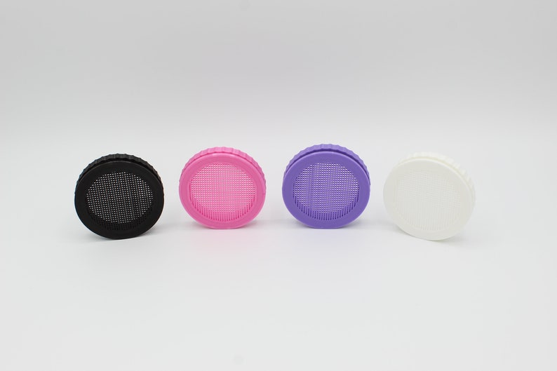 May include: Four round bottle caps with a mesh screen. The caps are black, pink, purple, and white.