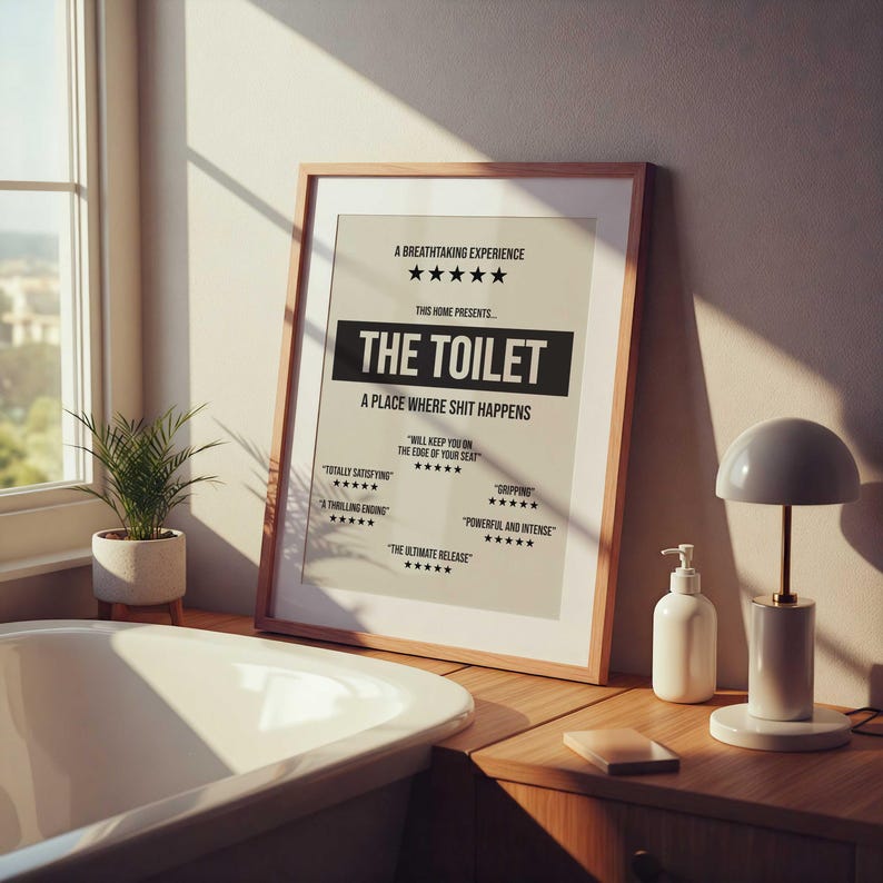 May include: A framed poster with a beige background and black text that reads: A BREATHTAKING EXPERIENCE, THE TOILET, A PLACE WHERE SHIT HAPPENS, WILL KEEP YOU ON THE EDGE OF YOUR SEAT, TOTALLY SATISFYING, A THRILLING ENDING, GRIPPING, POWERFUL AND INTENSE, THE ULTIMATE RELEASE.