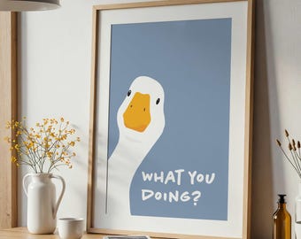 May include: A framed wall art print featuring a white goose with an orange beak against a dusty blue background. The text WHAT YOU DOING? is printed in white capital letters in the lower right corner of the illustration.