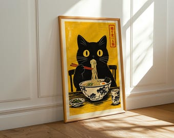 May include: A framed art print featuring a black cat with large yellow eyes eating noodles from a bowl with red chopsticks. The background is a vibrant yellow with Japanese text in the corner. The bowl and cup have a blue floral pattern.