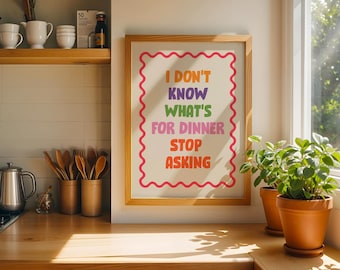 May include: A framed wall art print featuring the text I DON'T KNOW WHAT'S FOR DINNER STOP ASKING in colorful block letters. The text is centered on a cream background, surrounded by a red wavy border inside a light wood frame.