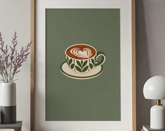 May include: A framed wall art print featuring a centered illustration of a coffee cup on a saucer. The cup is cream-colored with a green leaf pattern and contains brown coffee with white heart-shaped latte art on a sage green background.
