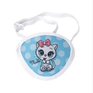 May include: A white eye patch with an adjustable strap. The patch features a blue background with white polka dots and a cartoon image of a white cat with pink bow and blue eyes. The text "Meow" is printed on the patch.