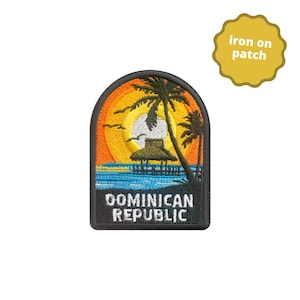 May include: Embroidered patch depicting a tropical sunset with palm trees, a pier, and the words "DOMINICAN REPUBLIC." The patch has a black border and is designed to be ironed on. The background features orange, yellow, and blue colours.