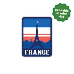 May include: A blue and red sticker with a silhouette of the Eiffel Tower and the French flag. The text "FRANCE" is printed in white below the image.