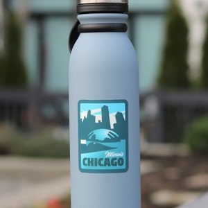May include: A light blue water bottle with a black lid and a sticker featuring a skyline and the text "Illinois CHICAGO".