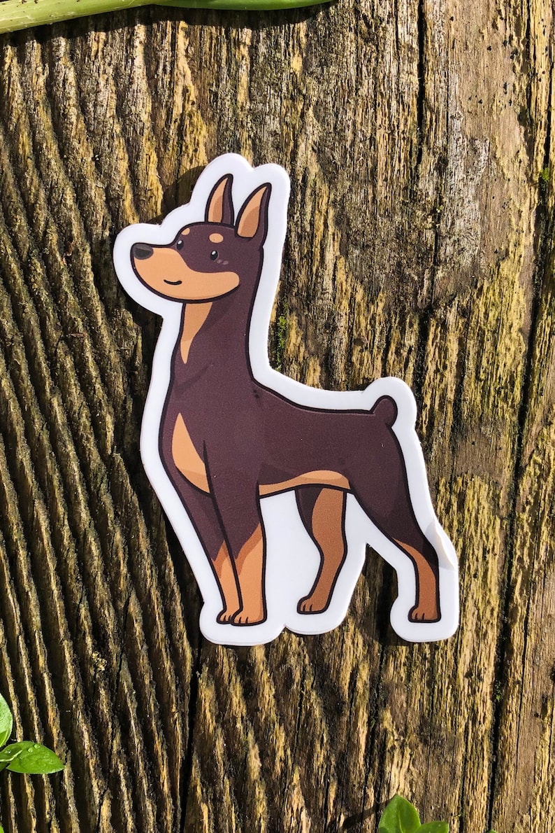May include: A brown and tan cartoon sticker of a Doberman Pinscher dog standing on its hind legs.