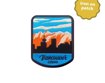 May include: An iron-on patch featuring a scenic view of Vancouver, Canada. The design includes a black skyline, orange mountains, blue sky, and the city's name in cursive. The patch is bordered in blue.