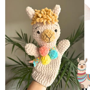 May include: A beige crochet llama hand puppet featuring a textured mustard yellow tuft of hair, a brown muzzle, and black eyes. The puppet is adorned with a colorful pom-pom scarf in shades of pink, yellow, and blue. Text reads: crochet pattern PDF.