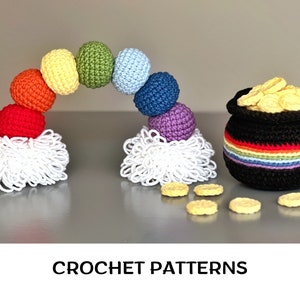May include: Crochet rainbow made of colorful balls with a pot of gold at the bottom. The rainbow is made of red, orange, yellow, green, blue, purple and white yarn. The pot of gold is black with a rainbow stripe and filled with yellow crocheted coins.