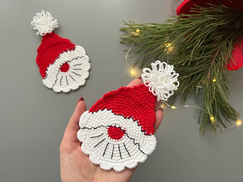 K&ouml;nnte beinhalten: Zwei geh&auml;kelte Weihnachtsm&uuml;tzen mit wei&szlig;en Bommeln. Die M&uuml;tzen sind rot und wei&szlig; mit einem wei&szlig;en H&auml;kelrand.