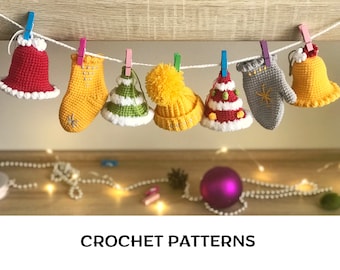 Puede incluir: Una colección de adornos navideños de ganchillo colgados de una cuerda. Los adornos incluyen una campana roja, una manopla amarilla, un árbol de Navidad verde y blanco, un gorro de Papá Noel amarillo y blanco, un árbol de Navidad rojo y blanco, una manopla gris y una campana amarilla.