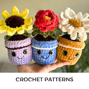 May include: Three colorful crochet flower pot dolls. The dolls have smiling faces and are in shades of purple, blue, and yellow. The flowers are a sunflower, a red rose, and a white daisy. The text "CROCHET PATTERNS" is at the bottom.