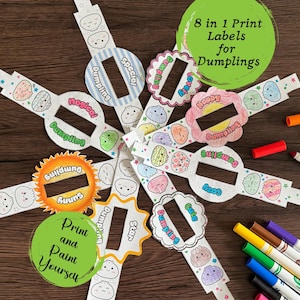 May include: A set of eight paper dumpling labels featuring various shapes and designs with printed text including Special, Magical, Sunny, Star, Cute, Cozy, Happy, and Lovely. The labels are partially colored and accompanied by several colorful markers.
