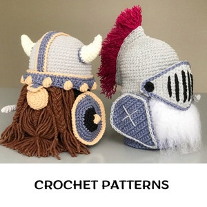 May include: Two crocheted gnome hats, one with a Viking helmet and shield and the other with a knight's helmet and shield. Both hats are gray with white accents and brown and white yarn beards.