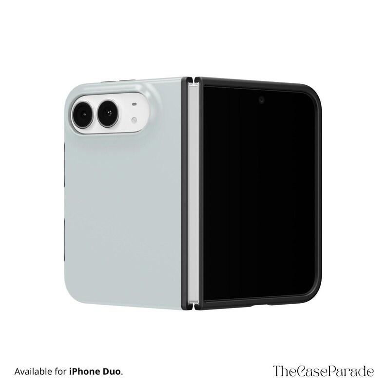 May include: A light grey foldable phone case for an iPhone Duo, featuring a black frame, a white camera module with two circular lenses, and a hinge mechanism. The text Available for iPhone Duo and TheCaseParade is visible.