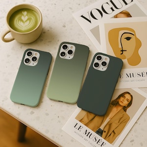 Könnte beinhalten: Drei grüne Handyhüllen mit Farbverlauf werden auf einer weiß gesprenkelten Oberfläche neben einer Tasse Matcha Latte und einer Zeitschrift präsentiert. Die Hüllen variieren in Grüntönen, von hell bis dunkel.
