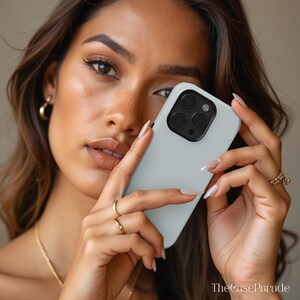 May include: A light grey smartphone case with a black camera module cutout. The case features a smooth, matte finish and is designed to fit a device with a triple-lens camera system. The text TheCaseParade is visible in the bottom right corner.