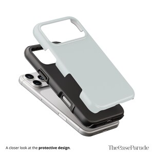 May include: A multi-layered smartphone case featuring a light grey outer shell, a black inner frame, and a silver smartphone. The text "A closer look at the protective design." and "TheCaseParade" are visible at the bottom of the image.