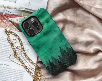 Op de afbeelding: Een smartphonehoesje met een groen boslandschap in aquarel-stijl met donkere silhouetten van dennenbomen aan de onderkant. Het hoesje heeft een zwarte camera-uitsparing en gaat vergezeld van een goudkleurige metalen ketting met platte schakels.
