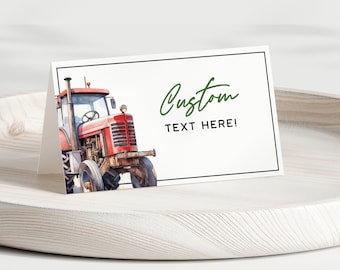 May include: A folded white card featuring a watercolour illustration of a red tractor. The card has a black border and the words "Custom TEXT HERE!" in green script. The card is displayed on a white wooden tray.