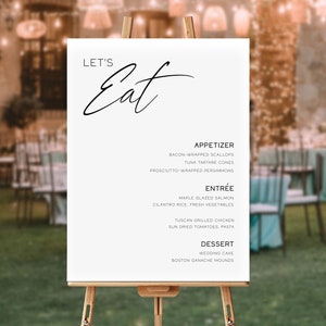Könnte beinhalten: Ein weißes Schild mit schwarzem Text auf einem Staffelei, auf dem "Let's Eat" steht. Das Schild listet ein Hochzeitsmenü mit Vorspeisen, Hauptgerichten und Desserts auf.
