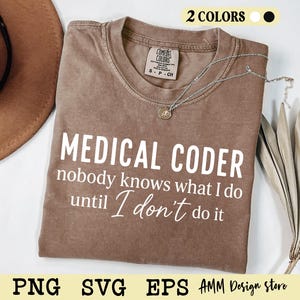 May include: A brown short-sleeved t-shirt with a crew neckline featuring the white printed text: MEDICAL CODER nobody knows what I do until I don't do it. The shirt has a Comfort Colors brand label inside the collar and a silver-toned necklace.