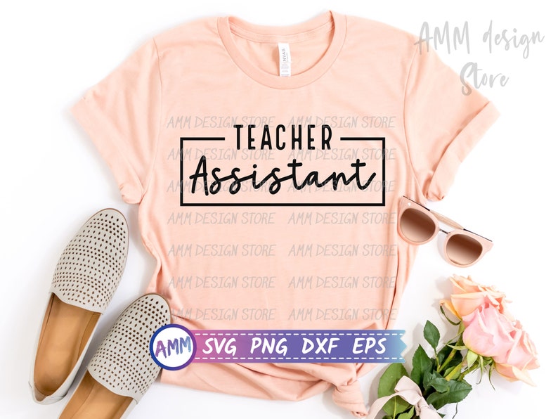May include: A pink t-shirt with the text "TEACHER-Assistant" in black lettering on a white rectangle. The shirt is laid flat on a white surface with a pair of beige shoes, sunglasses, and pink flowers.