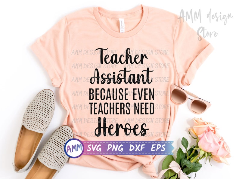 May include: A pink t-shirt with the text "Teacher Assistant Because Even Teachers Need Heroes" in black lettering. The shirt is laid flat on a white surface with a pair of beige shoes and sunglasses.