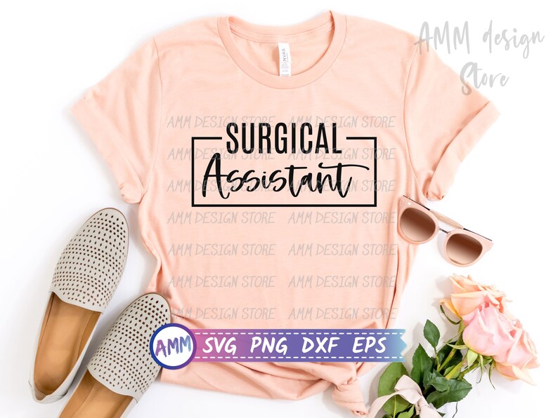 以下が含まれることがあります： ピーチ色のTシャツに、黒い長方形の中に「SURGICAL Assistant」という文字が書かれています。Tシャツは白い背景に置かれ、ベージュの靴、サングラス、ピンクのバラが置かれています。