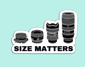 May include: A sticker with a black and white illustration of four camera lenses of different sizes. The text "SIZE MATTERS" is below the lenses.