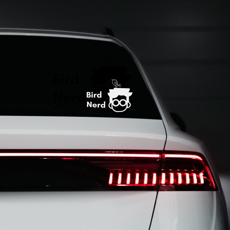 May include: White vinyl sticker with a cartoon illustration of a person wearing glasses with a bird on their head. The text "Bird Nerd" is above the illustration.